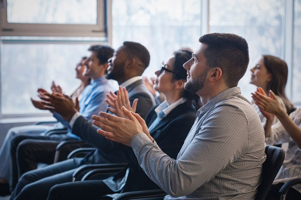 audience members applauding in a small meeting room